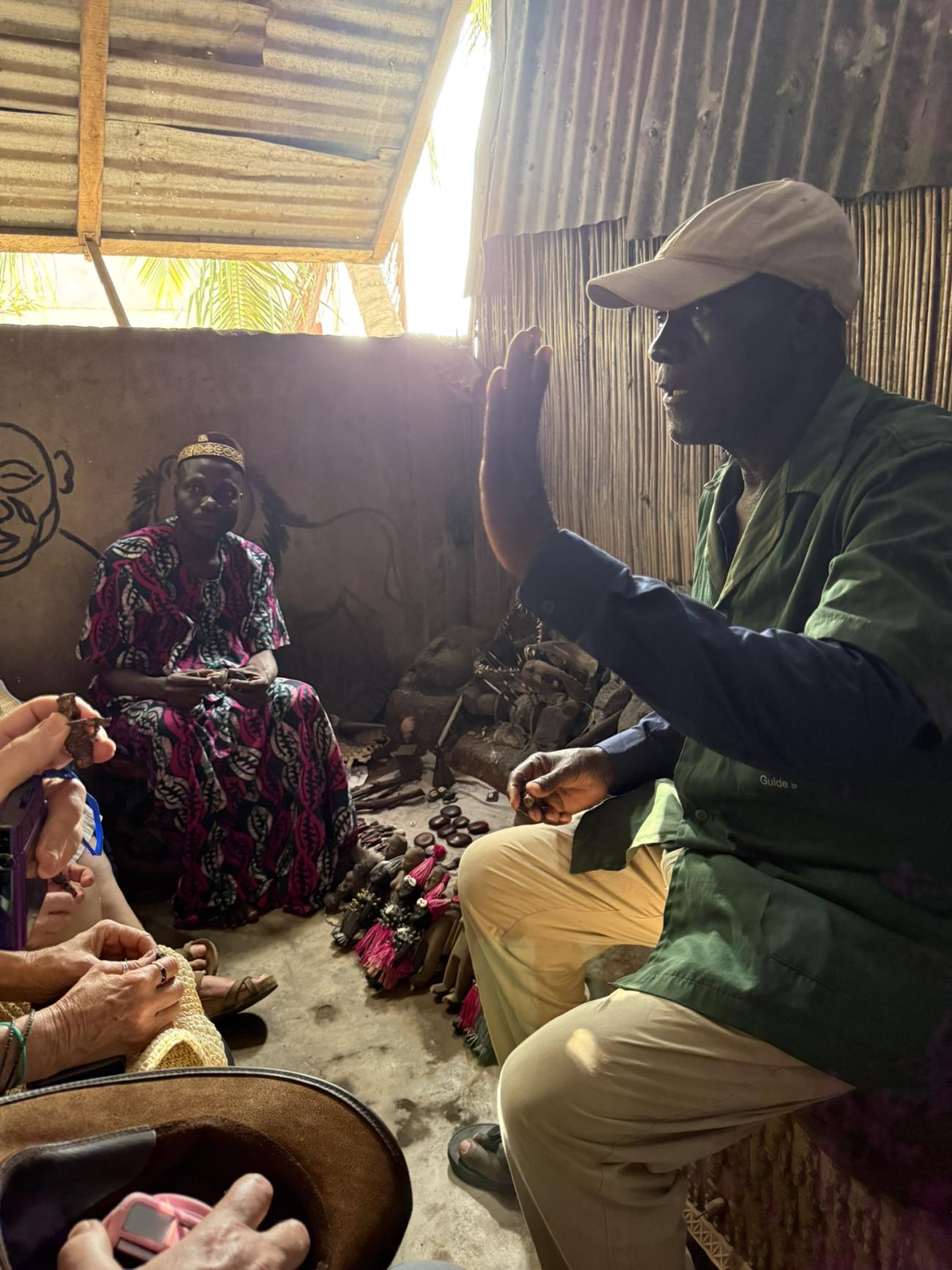 Man speaking to a group inside a home at the fetish market in Lome, Togo